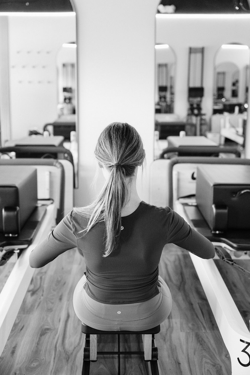 Black-and-white photo of a client on a reformer during a cardio session